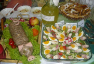 Zdjęcie przedstawia potrawę prosiaczek, obok pólmisek z jajami i szynką 