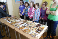 dzieci pokazujące swoje mazurkowe wypieki urzędniką 