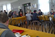 grupa uczestników Seminarium Informacyjno-Promocyjnego portalu NGO podczas zajęć siedzą przy stołach z żółtymi obrusami