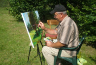 Zdjęcie przedstawia Pana Jerzego Kacprowskiego podczas malowania obrazu na łonie natury