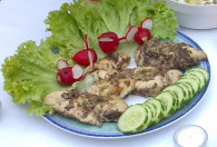 Grillowana pierś z kurczaka na talerzu ozdobionym sałatą, rzodkiewką oraz ogórkiem